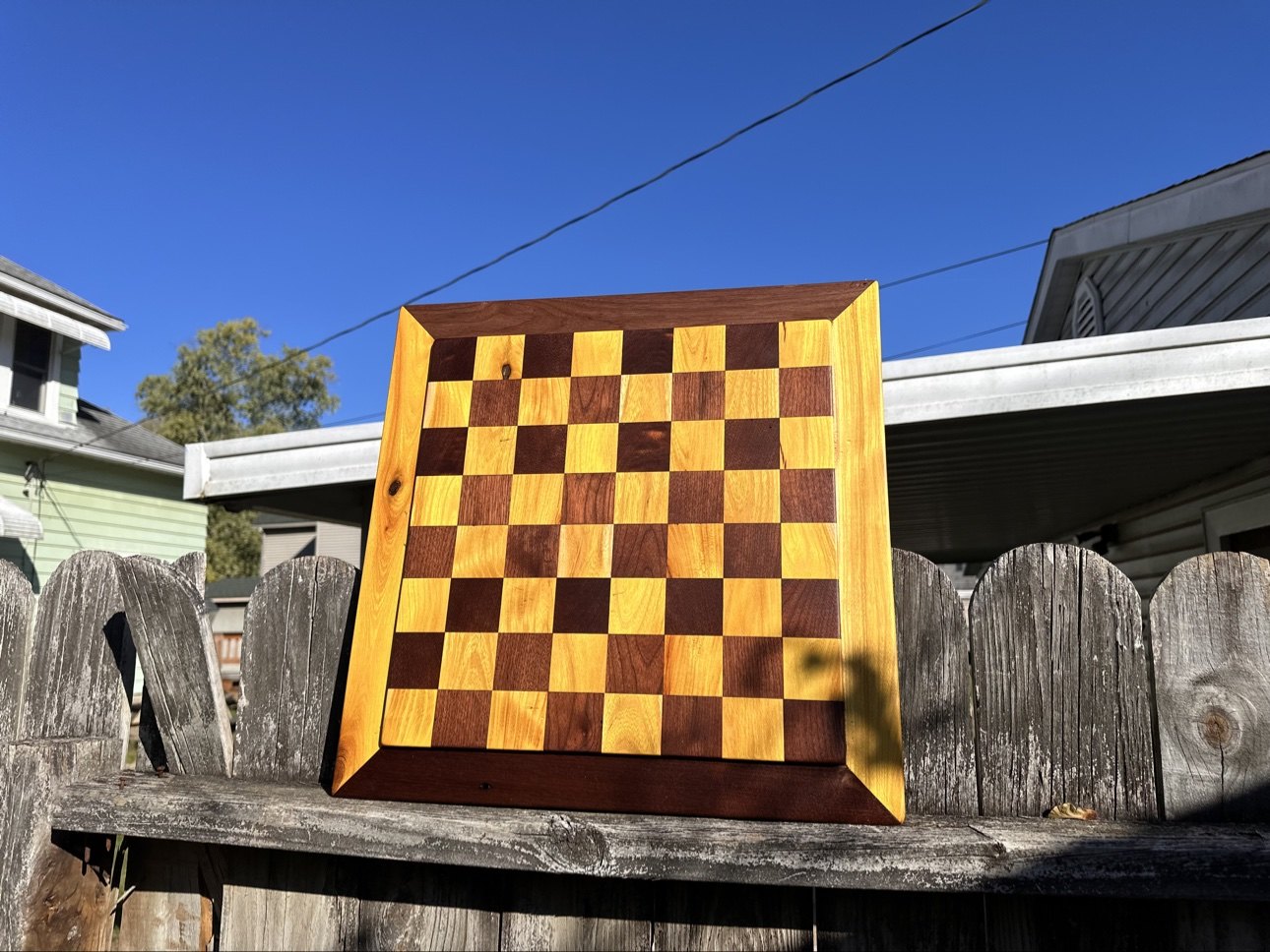 Chessboard with yellow and dark brown squares in a golden frame